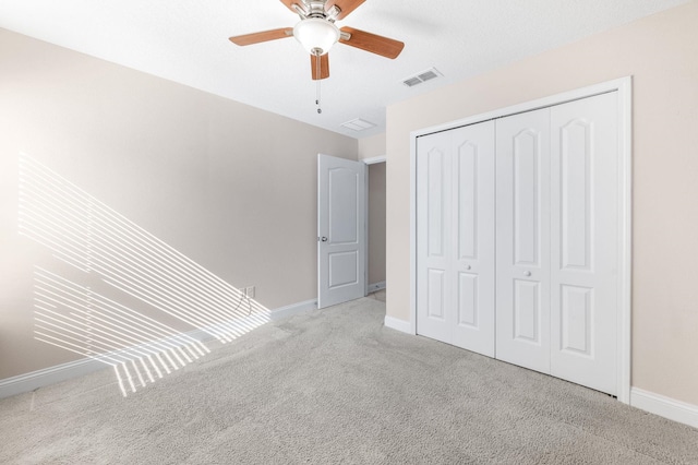 unfurnished bedroom featuring carpet flooring, baseboards, a closet, and a ceiling fan