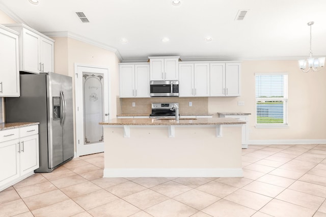 kitchen featuring appliances with stainless steel finishes, ornamental molding, decorative backsplash, light tile patterned flooring, and a kitchen bar