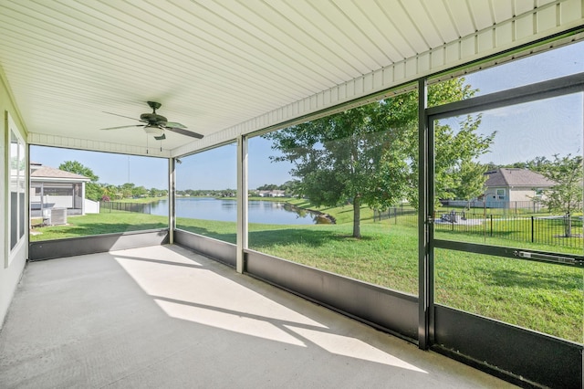 unfurnished sunroom with ceiling fan and a water view