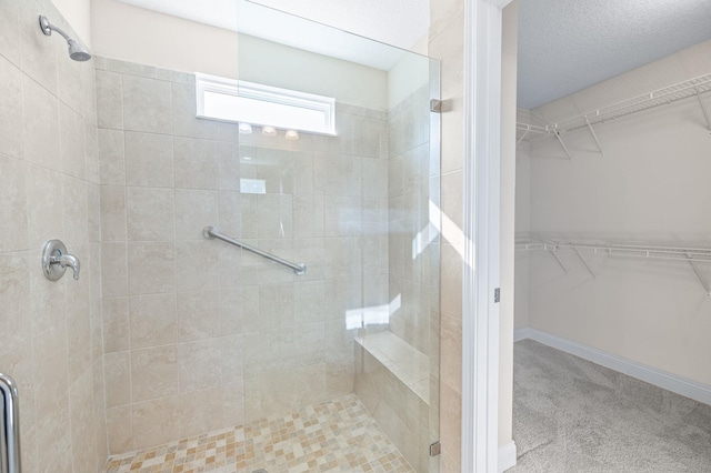 bathroom featuring a stall shower and a spacious closet