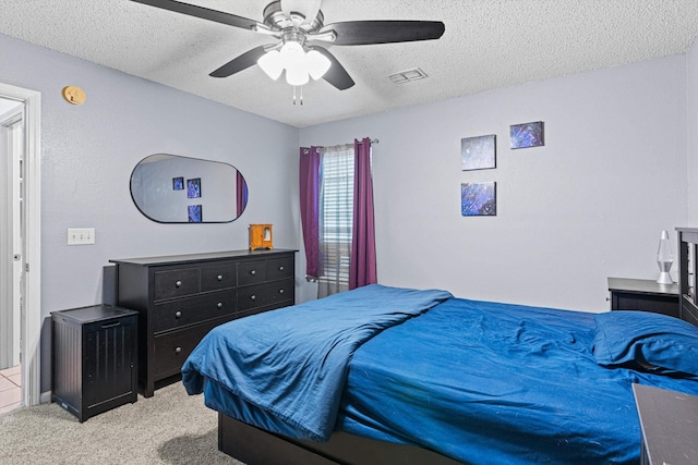 bedroom featuring ceiling fan, light carpet, and a textured ceiling