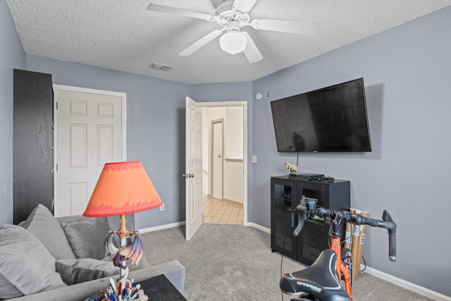 carpeted living room with ceiling fan and a textured ceiling