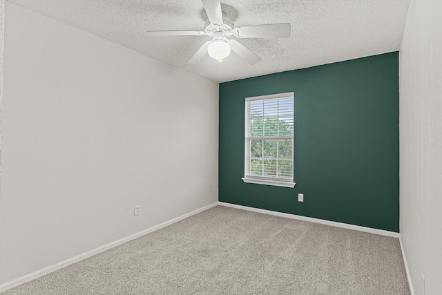 carpeted spare room with a textured ceiling and ceiling fan