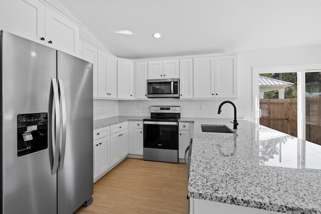 237 Jackson Blvd, Saint Augustine, FL 32095 - kitchen featuring white cabinets, a peninsula, tasteful backsplash, appliances with stainless steel finishes, and a sink