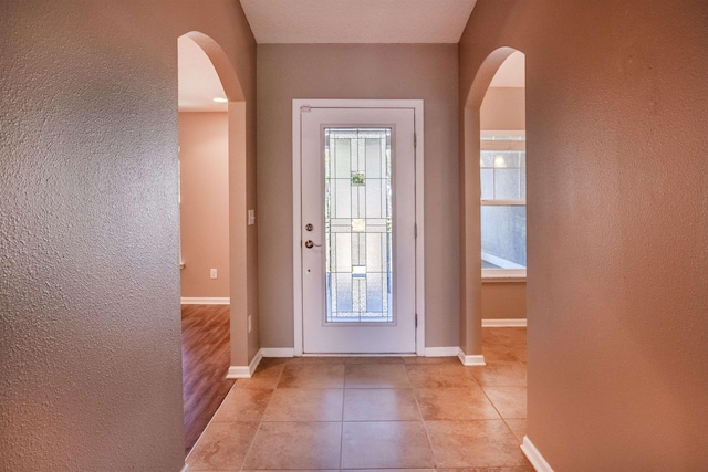 doorway to outside with light tile patterned floors and a healthy amount of sunlight