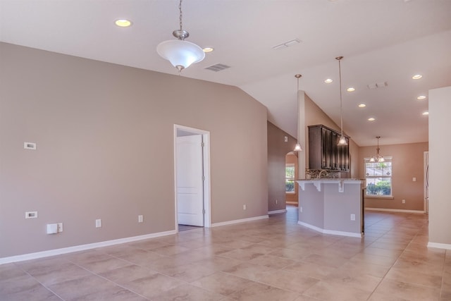 interior space with lofted ceiling, a chandelier, and light tile patterned floors