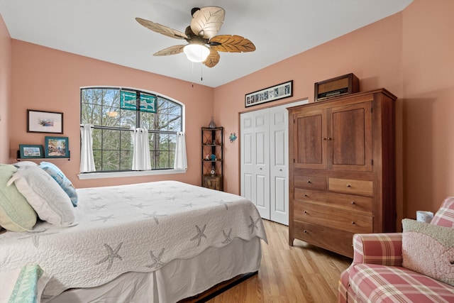 bedroom featuring light wood-style flooring, ceiling fan, and a closet