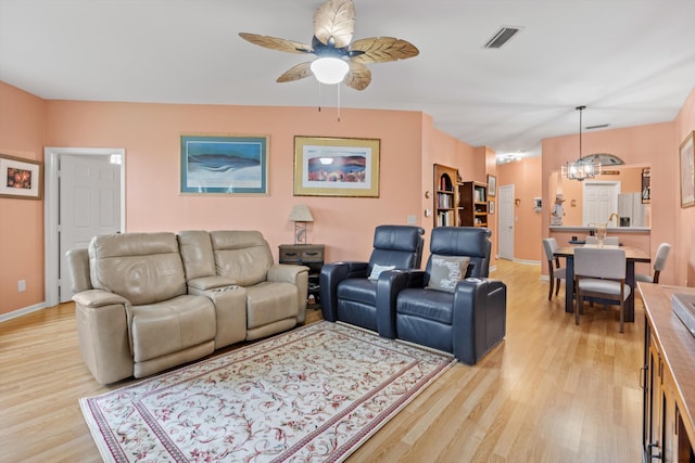 living area with light wood-style floors, visible vents, and baseboards