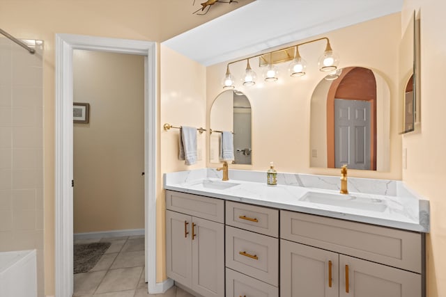 bathroom featuring a tub to relax in, double vanity, a sink, and tile patterned floors