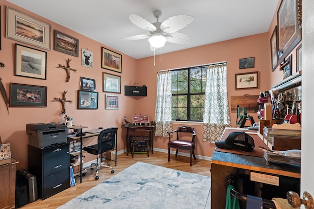 office area with light wood-style floors, ceiling fan, and baseboards