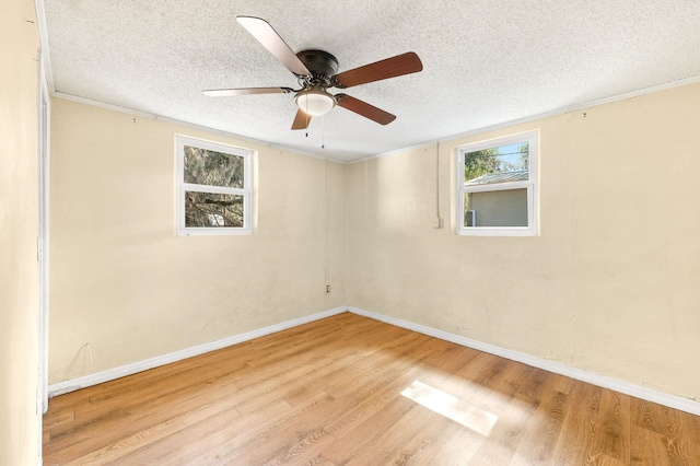 unfurnished room featuring crown molding, light wood-style floors, a ceiling fan, a textured ceiling, and baseboards