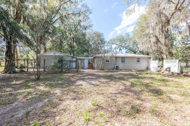 back of house with concrete block siding and fence