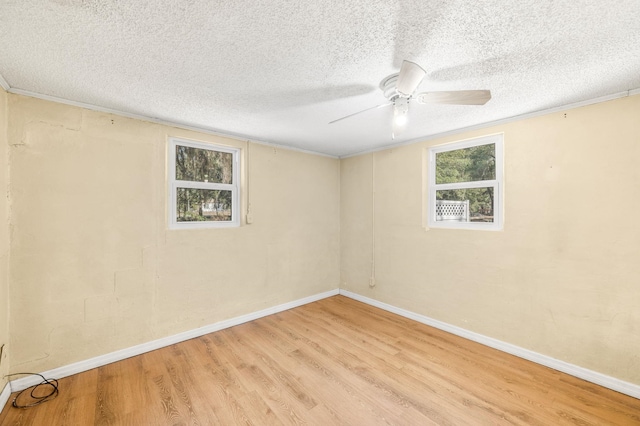 unfurnished room with a textured ceiling, a ceiling fan, baseboards, ornamental molding, and light wood finished floors