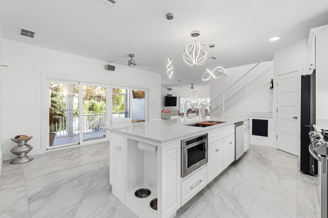 kitchen featuring visible vents, marble finish floor, stainless steel appliances, a sink, and ceiling fan with notable chandelier