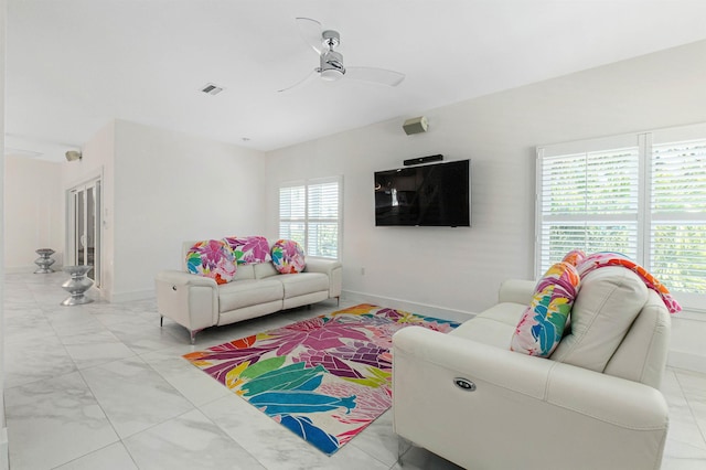 living room with visible vents, ceiling fan, and baseboards