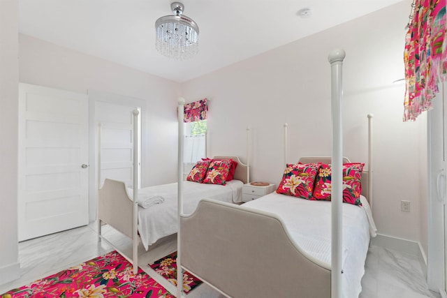 bedroom featuring marble finish floor and an inviting chandelier