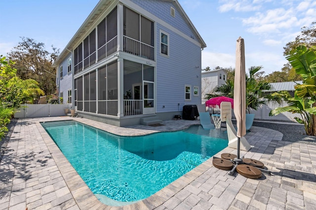 view of pool featuring a patio area, a fenced backyard, a sunroom, and a fenced in pool