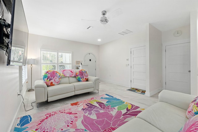 living area with marble finish floor, ceiling fan, and baseboards