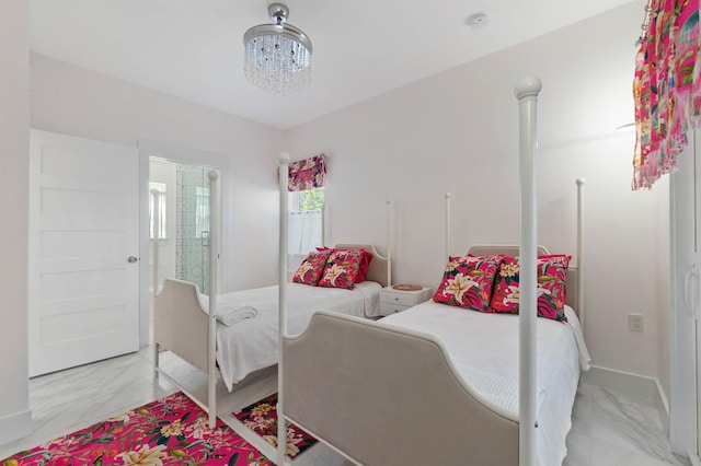 bedroom featuring marble finish floor and a chandelier