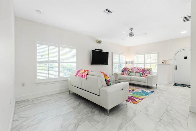 living room with marble finish floor, baseboards, visible vents, and a ceiling fan