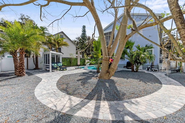 exterior space with a sunroom, a fenced backyard, and a fenced in pool