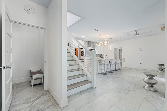 staircase featuring ceiling fan, marble finish floor, visible vents, and baseboards