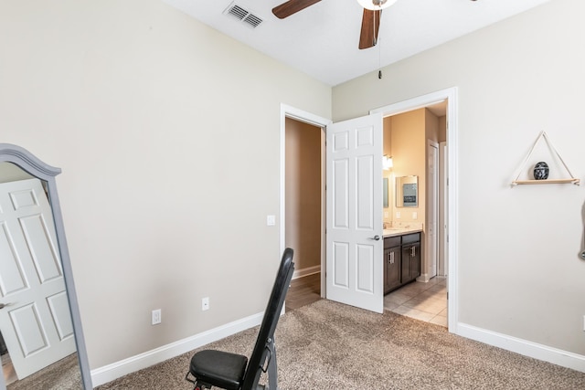 workout room with light colored carpet and ceiling fan