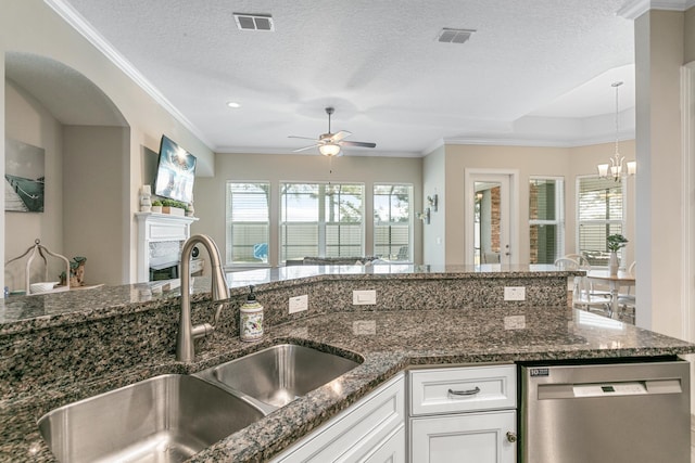 kitchen with sink, stainless steel dishwasher, white cabinets, and dark stone counters