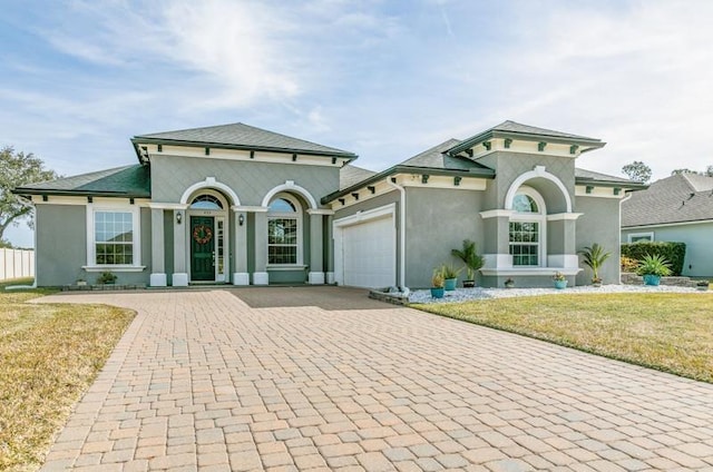 mediterranean / spanish-style house with a garage and a front yard