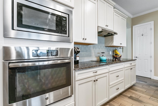 kitchen with crown molding, dark stone countertops, stainless steel appliances, light hardwood / wood-style floors, and white cabinets