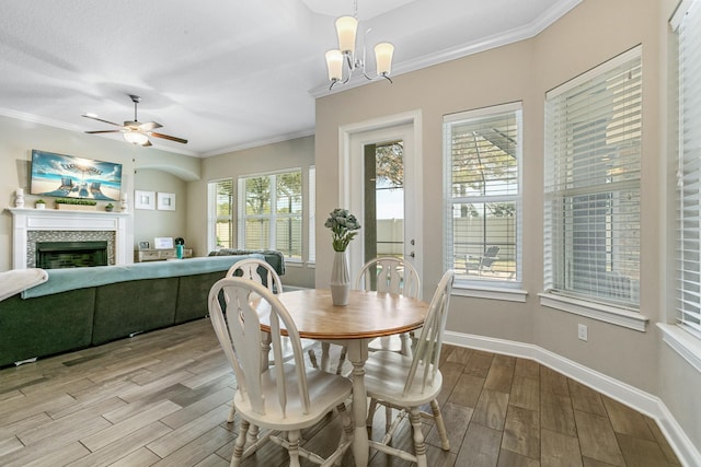 dining area with crown molding and ceiling fan with notable chandelier