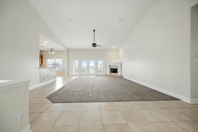500 Seagate Ln, Saint Augustine, FL 32084 - unfurnished living room featuring a ceiling fan, light tile patterned flooring, high vaulted ceiling, baseboards, and light carpet