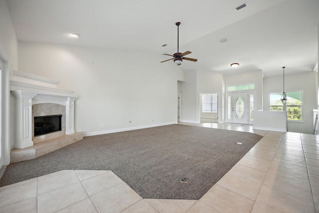 500 Seagate Ln, Saint Augustine, FL 32084 - unfurnished living room featuring tile patterned flooring, a ceiling fan, a fireplace, baseboards, and a high ceiling