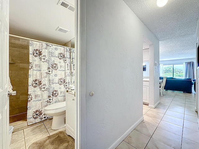 826 A1A Beach Blvd Unit 13, Saint Augustine, FL 32080 - full bath with toilet, tile patterned flooring, a textured ceiling, and a tile shower