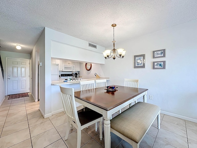 826 A1A Beach Blvd Unit 13, Saint Augustine, FL 32080 - dining space with a chandelier, a textured ceiling, light tile patterned floors, and baseboards
