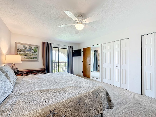 826 A1A Beach Blvd Unit 13, Saint Augustine, FL 32080 - carpeted bedroom featuring two closets, a textured ceiling, access to exterior, and a ceiling fan