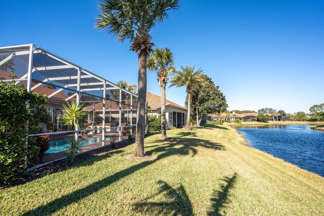 view of yard featuring a lanai and a water view