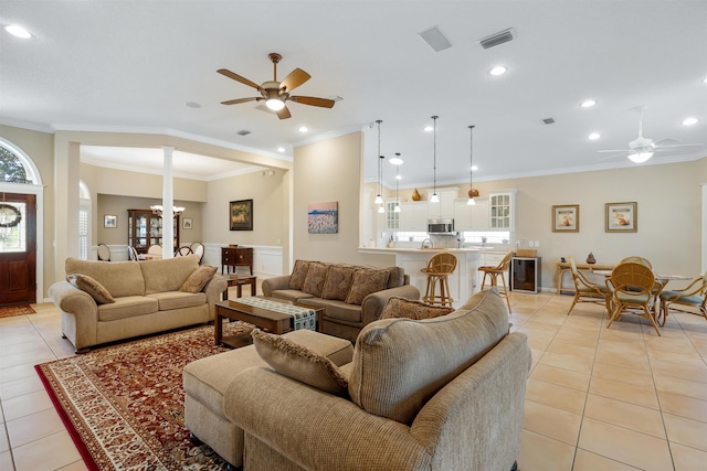 living area with a ceiling fan, light tile patterned flooring, visible vents, and crown molding