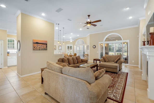 living area featuring baseboards, a ceiling fan, ornamental molding, a fireplace, and light tile patterned flooring