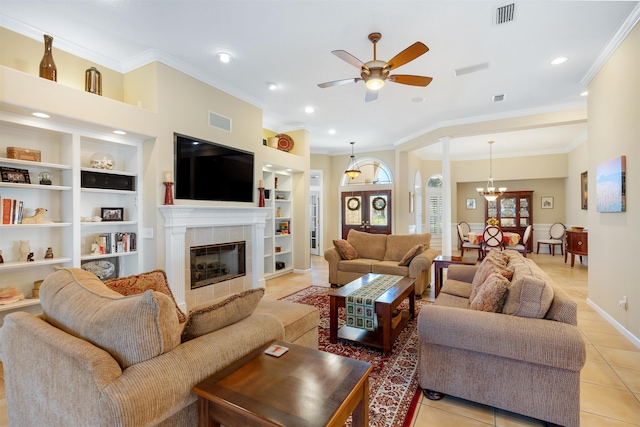 living room featuring visible vents, a tile fireplace, crown molding, built in shelves, and light tile patterned flooring