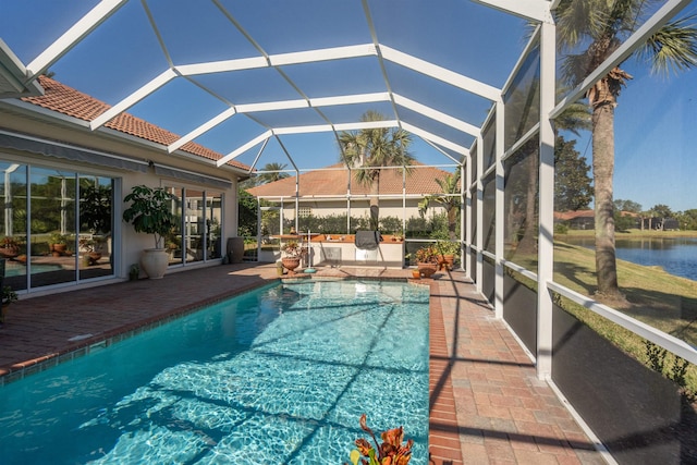 pool with a water view, a patio area, and a lanai