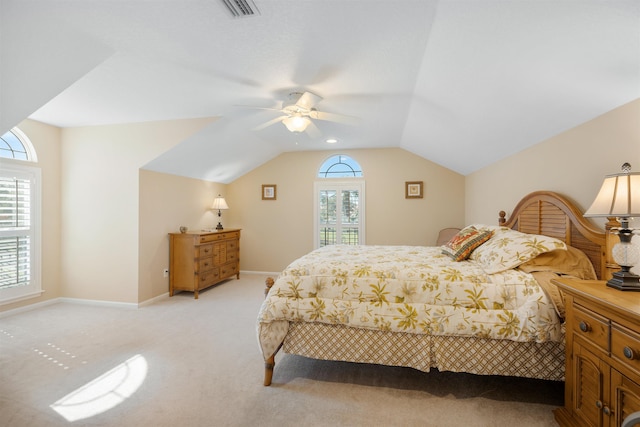 bedroom featuring lofted ceiling, light colored carpet, visible vents, a ceiling fan, and baseboards