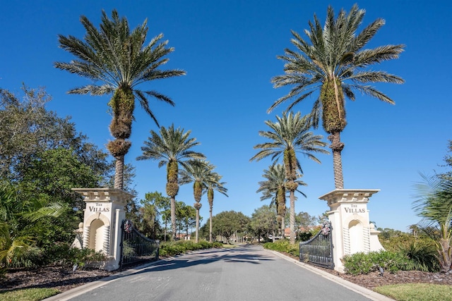 view of street featuring a gate, curbs, and a gated entry