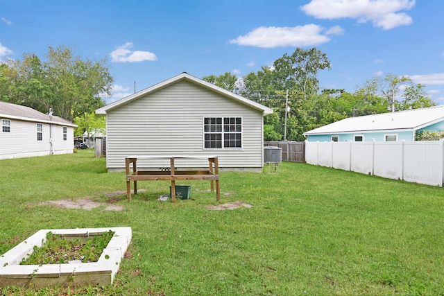 67 Anderson St, Saint Augustine, FL 32084 - back of property featuring a lawn, fence, and cooling unit