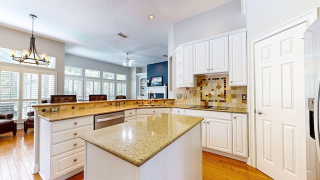 12232 Lashbrook Ct, Jacksonville, FL 32223 - kitchen featuring stainless steel dishwasher, a peninsula, a ceiling fan, light wood-style floors, and light stone countertops
