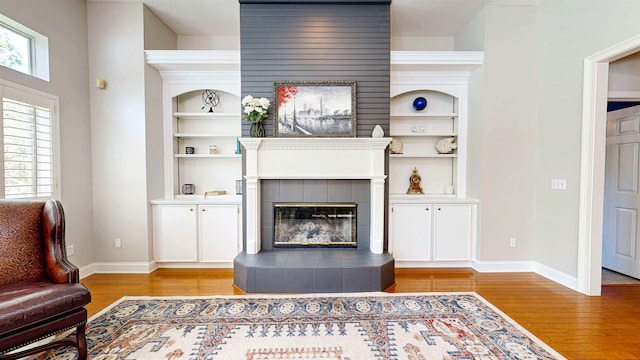 12232 Lashbrook Ct, Jacksonville, FL 32223 - living room with wood finished floors, baseboards, a tiled fireplace, and built in shelves