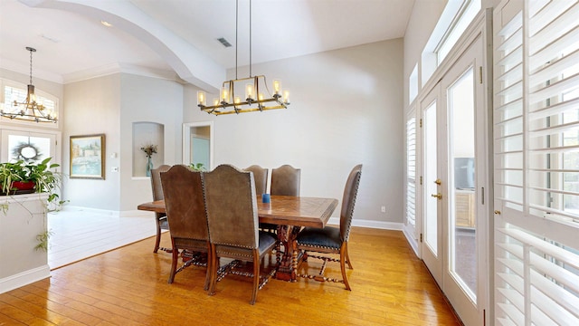 12232 Lashbrook Ct, Jacksonville, FL 32223 - dining space with a chandelier, light wood finished floors, arched walkways, baseboards, and crown molding