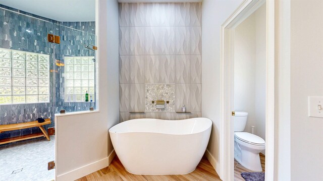 12232 Lashbrook Ct, Jacksonville, FL 32223 - bathroom with a soaking tub, wood finished floors, baseboards, and toilet