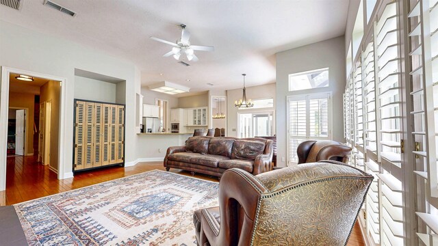 12232 Lashbrook Ct, Jacksonville, FL 32223 - living room with ceiling fan, a chandelier, baseboards, and wood finished floors