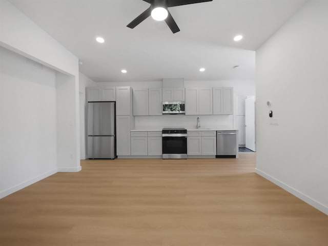 kitchen with baseboards, ceiling fan, appliances with stainless steel finishes, light wood-style floors, and recessed lighting